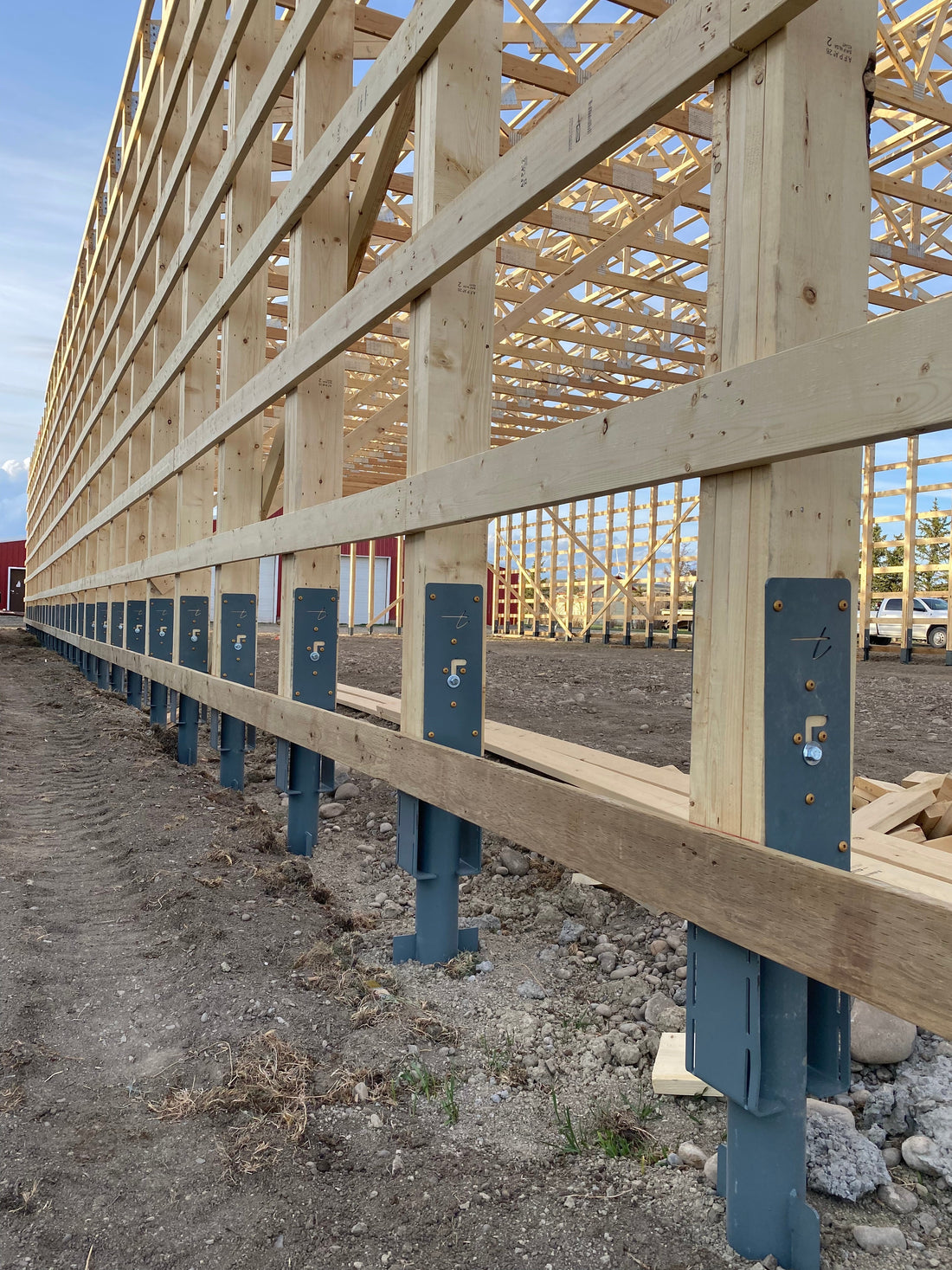 Steel post foundation system for post-frame building construction